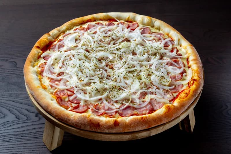 Pizza de calabresa recém-saída do forno, com cebola e orégano